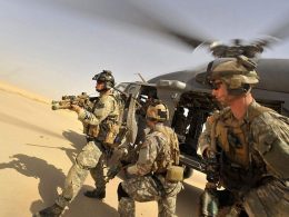 Operators from Task Force 121 and US Air Force Pararescue Jumpers (PJs) exiting from a helicopter