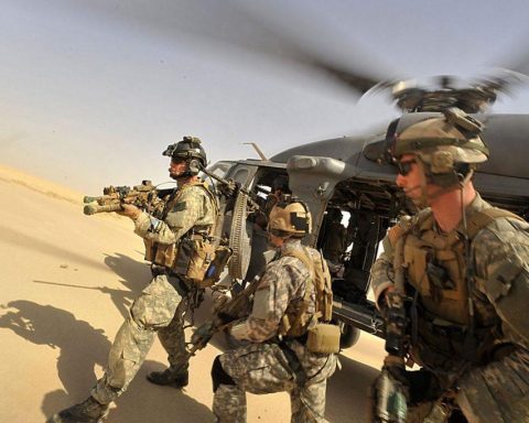 Operators from Task Force 121 and US Air Force Pararescue Jumpers (PJs) exiting from a helicopter