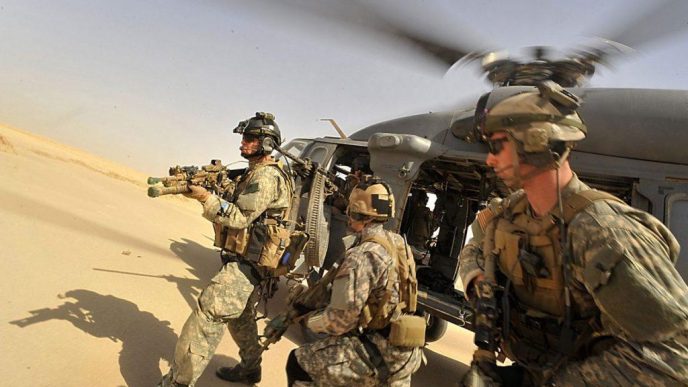 Operators from Task Force 121 and US Air Force Pararescue Jumpers (PJs) exiting from a helicopter
