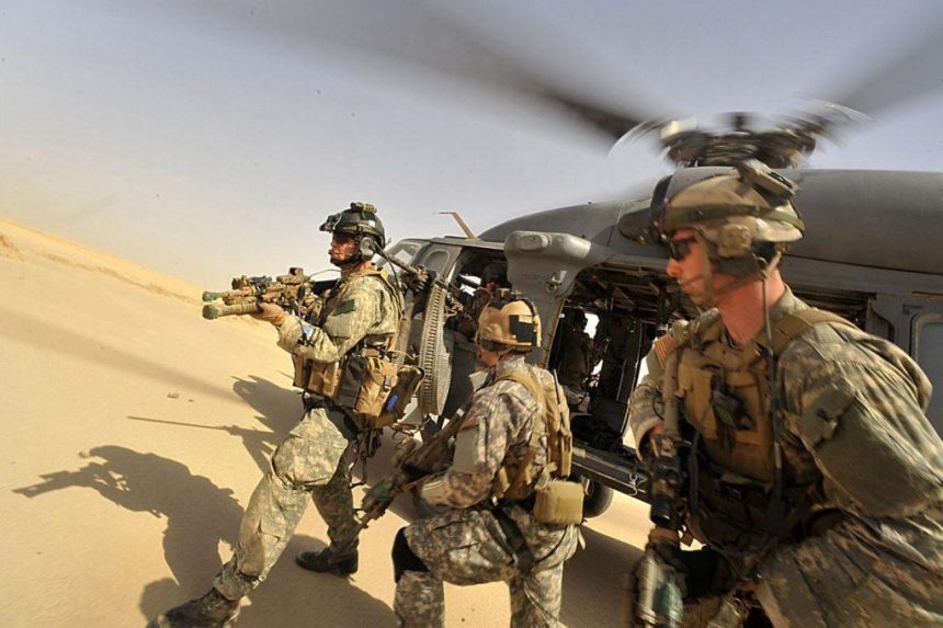 Operators from Task Force 121 and US Air Force Pararescue Jumpers (PJs) exiting from a helicopter