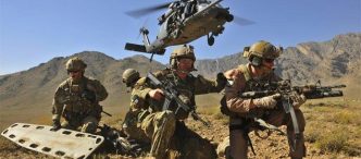 US Air Force Pararescue Jumpers (PJs) deployed, helicopter taking off in the background