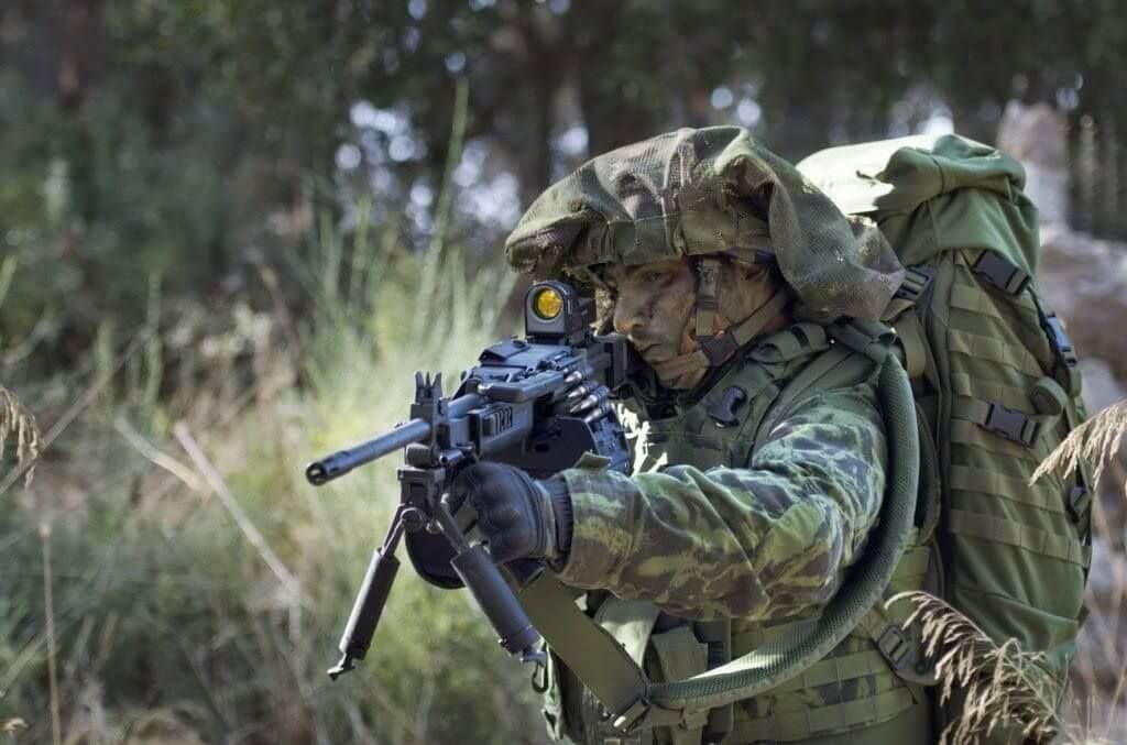 Soldier standing with IWI Negev light machine gun