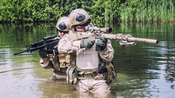 Two U.S. Navy Seals navigating through swamp during the training