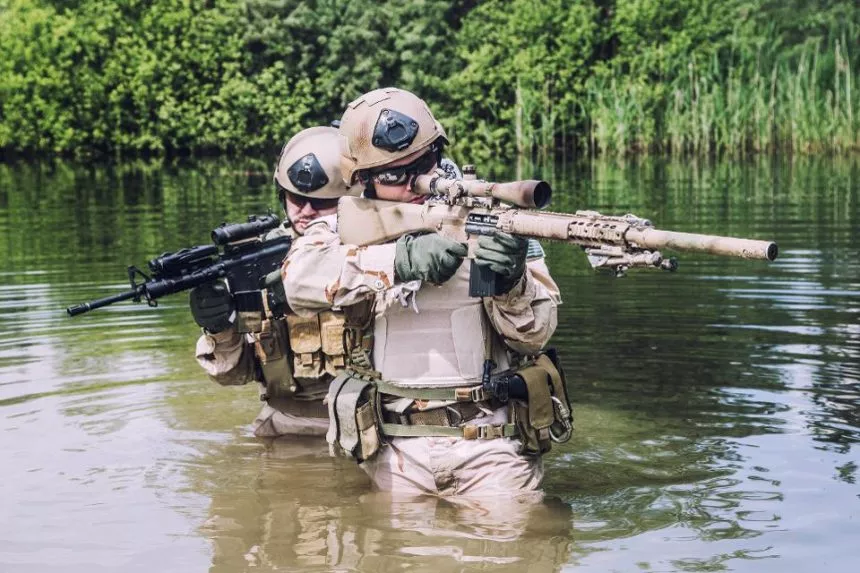 Two U.S. Navy Seals navigating through swamp during the training