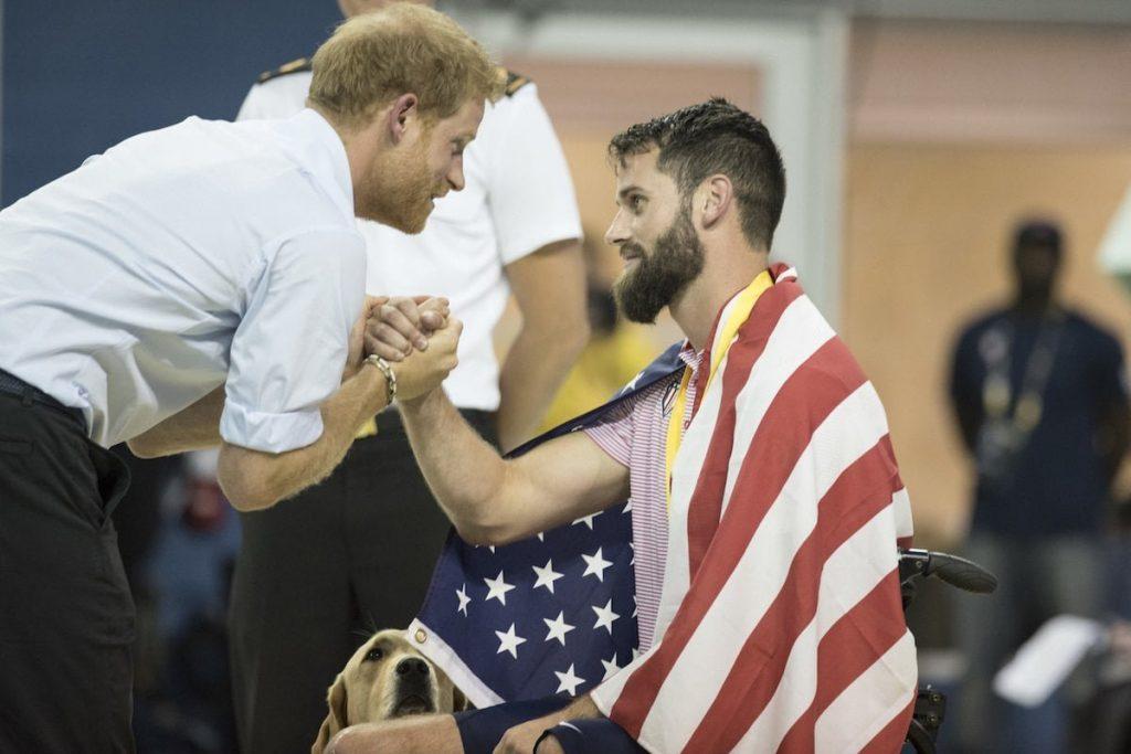 Prince Harry and an American wounded warrior in a wheelchair shake hands at the 2017 Invictus Games in Toronto