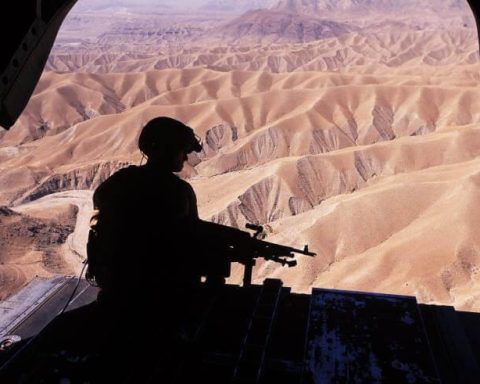 A silhouette of a flight engineer manning an M240 machine gun on the ramp of a CH-47D Chinook in eastern Afghanistan