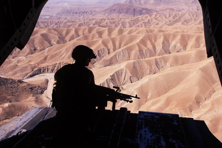 A silhouette of a flight engineer manning an M240 machine gun on the ramp of a CH-47D Chinook in eastern Afghanistan