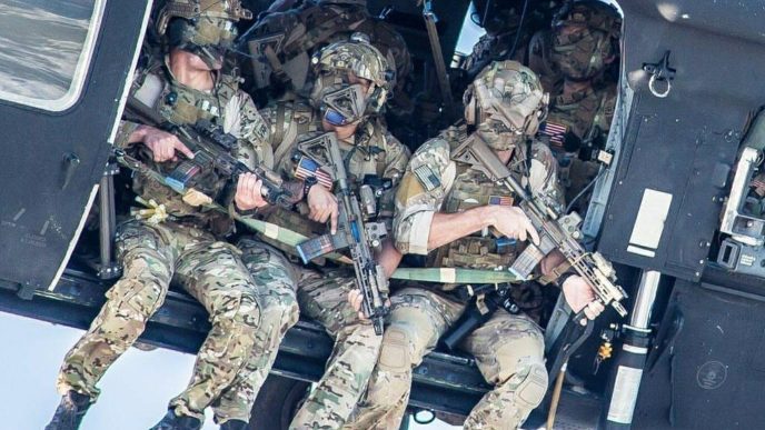 A group of Delta Force operators armed with HK416 assault rifles hanging out from the Blackhawk
