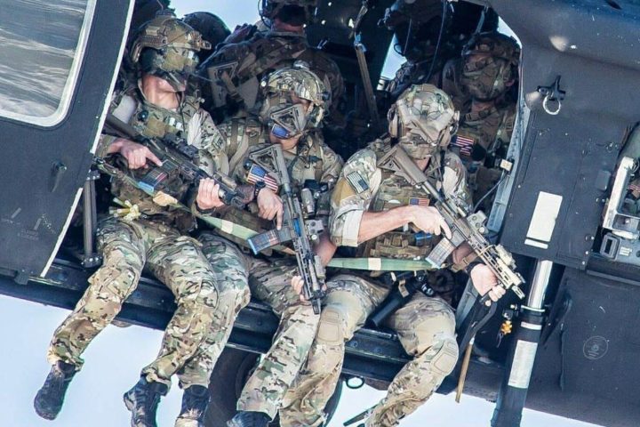 A group of Delta Force operators armed with HK416 assault rifles hanging out from the Blackhawk