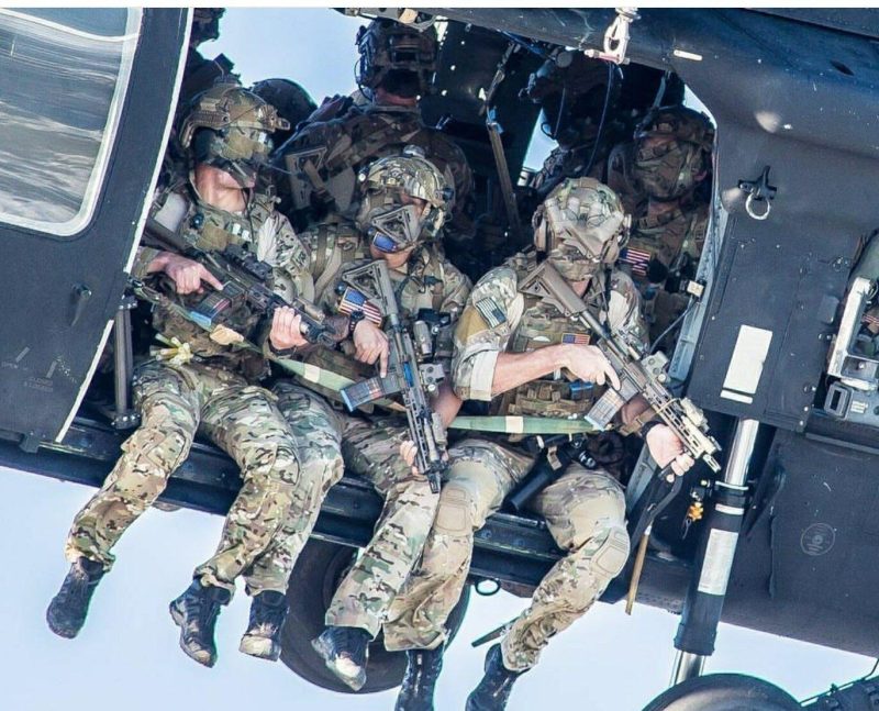 A group of Delta Force operators armed with HK416 assault rifles hanging out from the Blackhawk