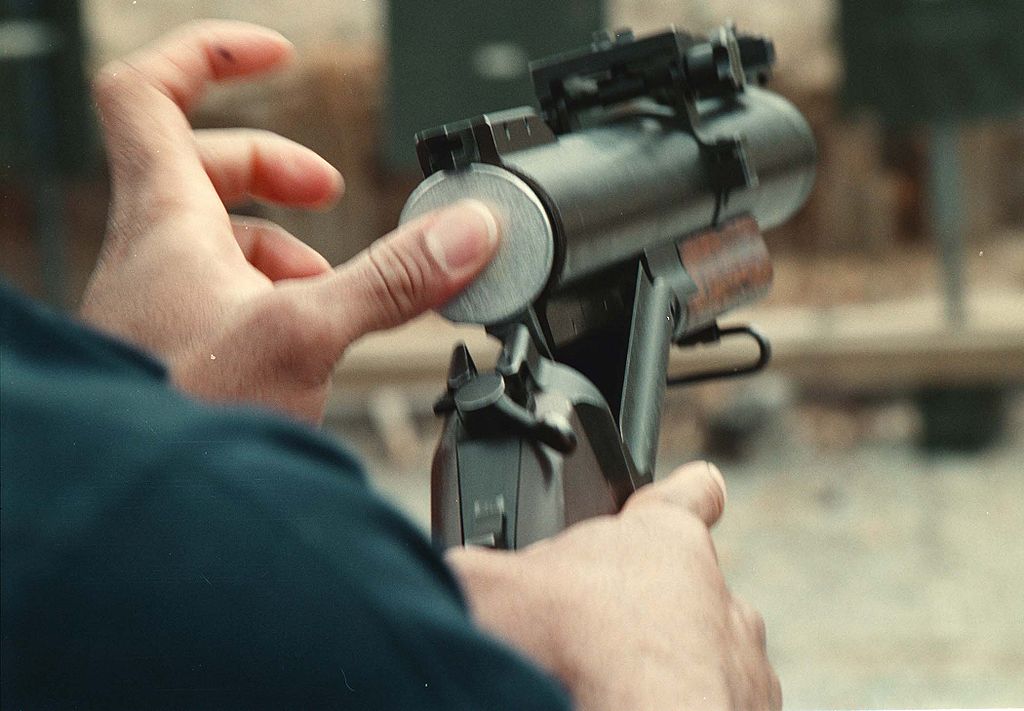 A less-lethal round is loaded into an M79 Grenade Launcher