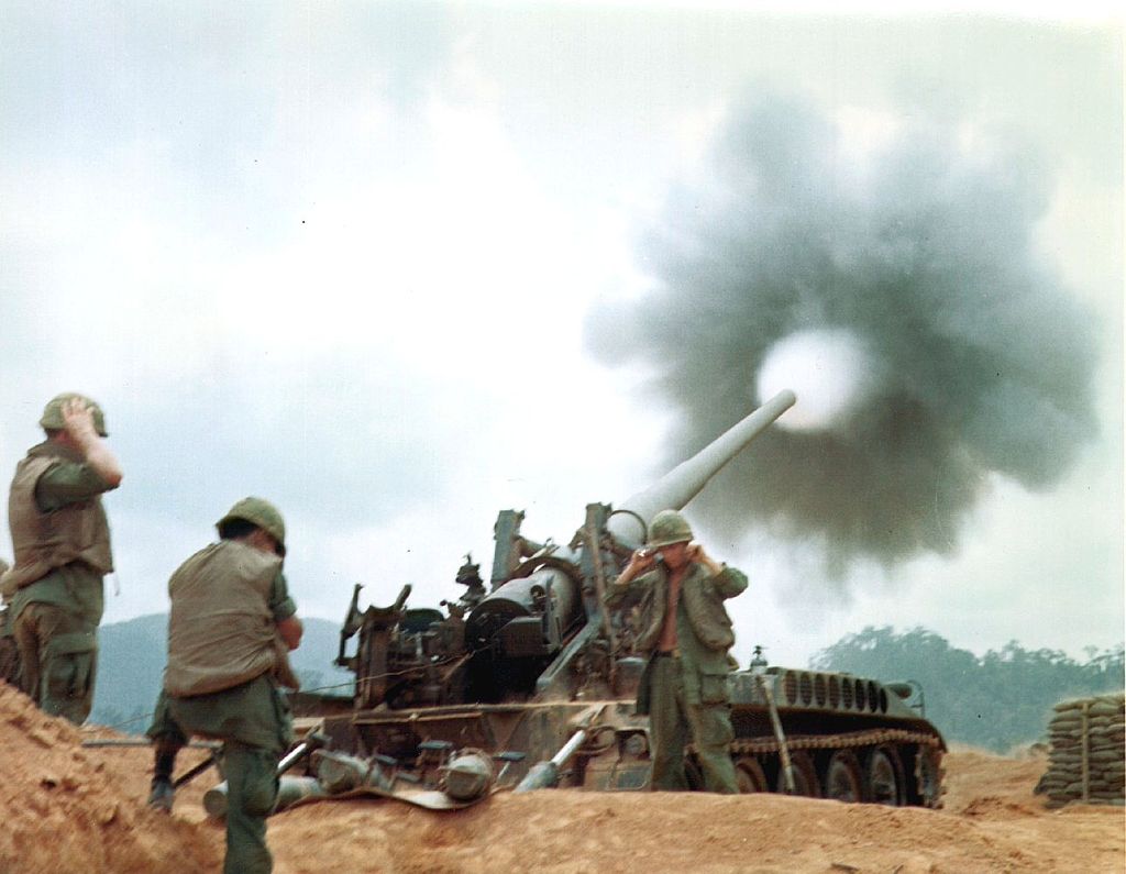 An M107 provides crucial fire support for friendly ground forces against enemy troops during the Vietnam War in 1968