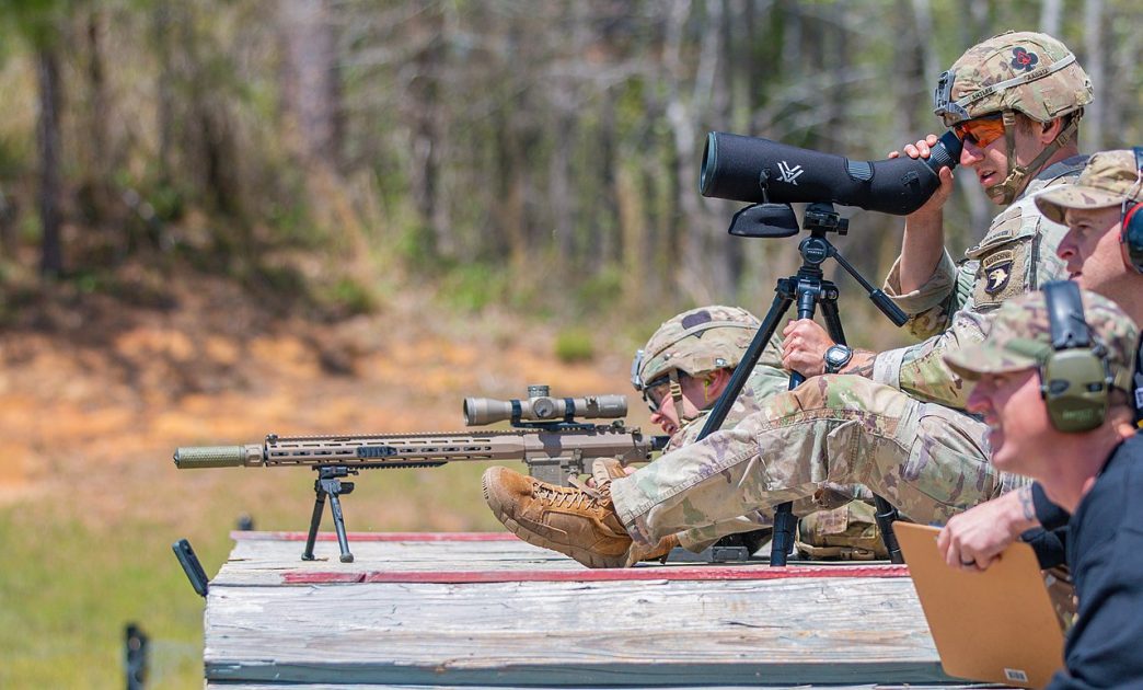 1st Lt. Aaron Arturi (front) and 1st Lt. John Ryan from the 101st Airborne Division (Air Assault), takes aim at stress shoot event at the Annual Best Ranger Competition in Fort Benning, Ga on April 9th, 2022. Ryan is aiming down range at the targets while Arturi is spotting him. The spotter helps the sniper stay on track so they can hit their target