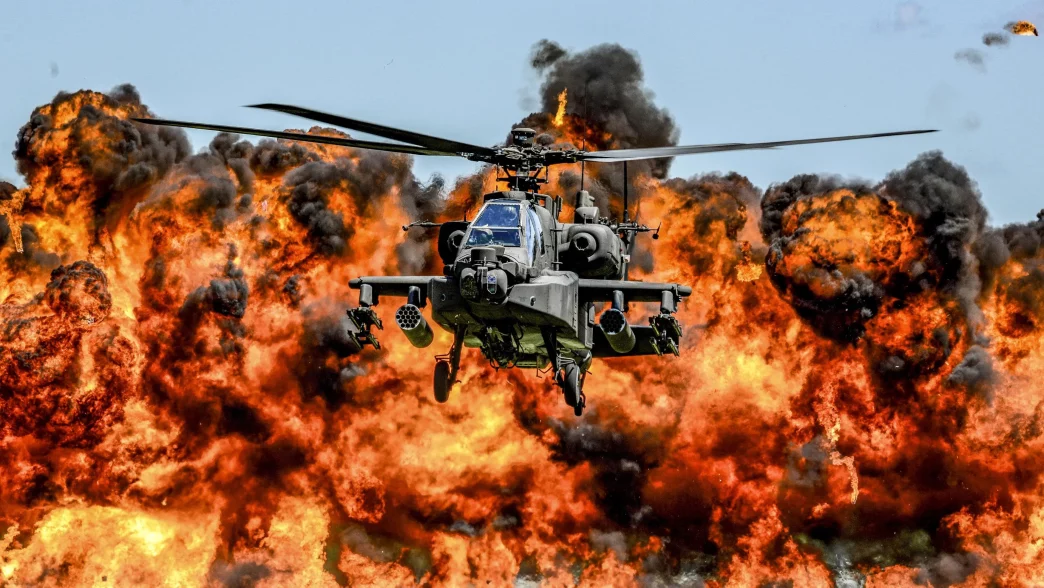 Apache helicopter flying through fire and smoke