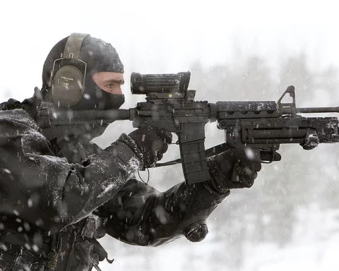 Special operations forces operator aiming through reflex sight on Colt Canada C7 rifle