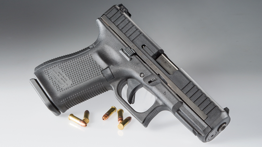 Glock 44 chambered for .22 LR on a grey background with rounds