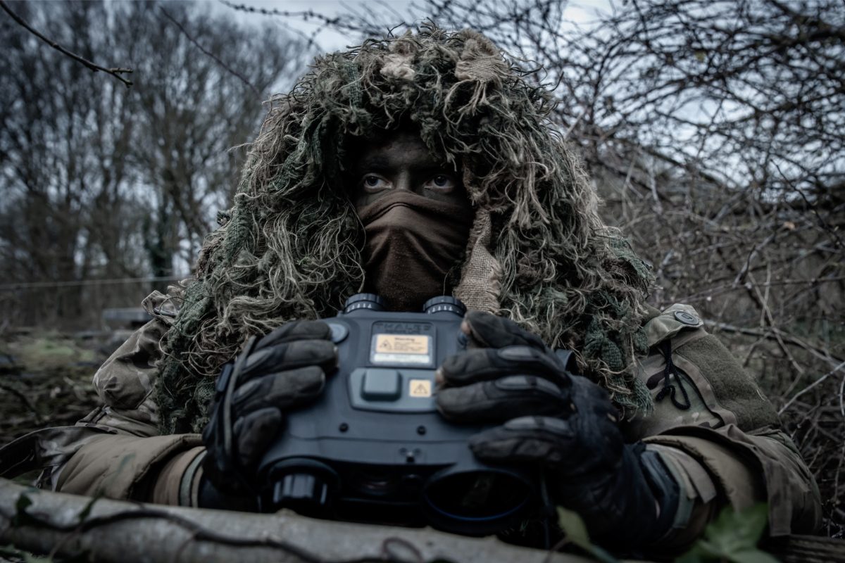 An operator from the 21st Special Reconnaissance Detachment with binoculars during the Basic Reconnaissance Course 2023