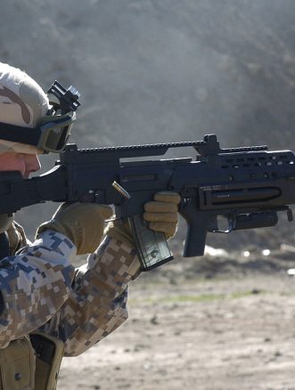 A Latvian soldier with a G36KV rifle is equipped with a Picatinny rail, a modified adjustable stock, and an AG36 grenade launcher