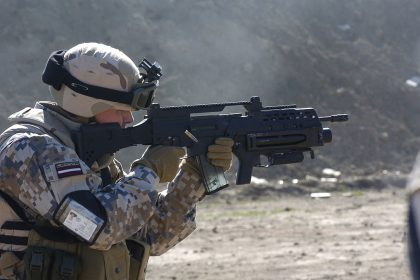 A Latvian soldier with a G36KV rifle is equipped with a Picatinny rail, a modified adjustable stock, and an AG36 grenade launcher