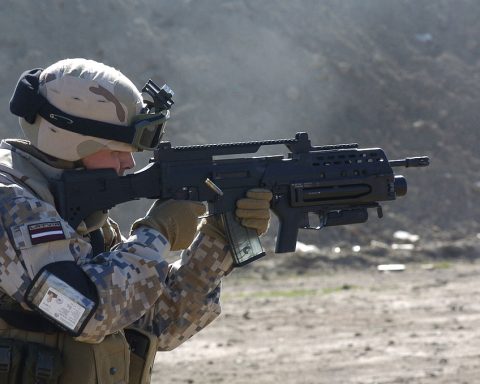 A Latvian soldier with a G36KV rifle is equipped with a Picatinny rail, a modified adjustable stock, and an AG36 grenade launcher