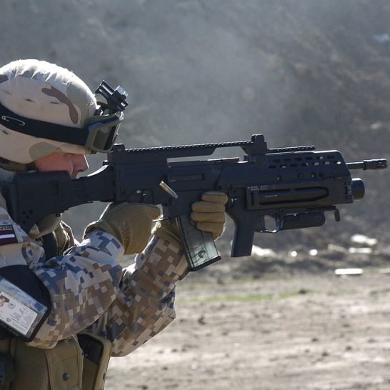 A Latvian soldier with a G36KV rifle is equipped with a Picatinny rail, a modified adjustable stock, and an AG36 grenade launcher