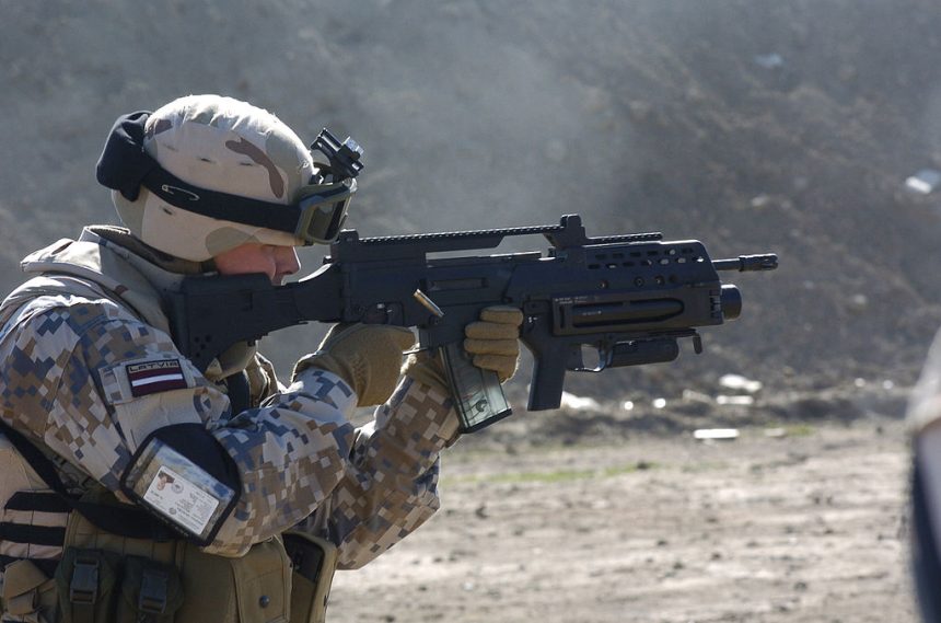 A Latvian soldier with a G36KV rifle is equipped with a Picatinny rail, a modified adjustable stock, and an AG36 grenade launcher