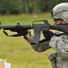 Soldier firing an M16 rifle at a target