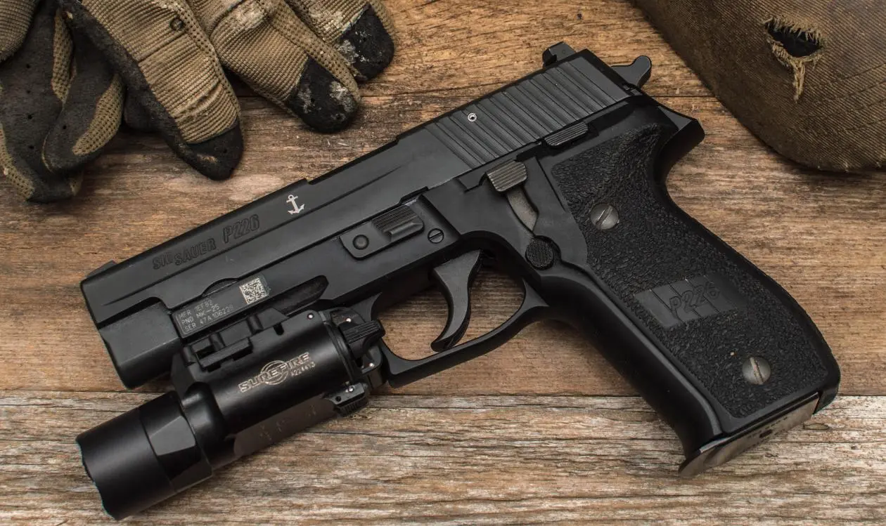 SIG Sauer P228 with flashlight attached on Picatinny rail