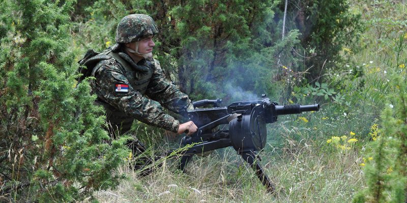 Serbian soldier firing Zastava M93 BGA automatic grenade launcher in a field setting