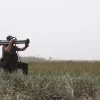 Soldier holding an RPG-30 shoulder-fired rocket launcher in a field