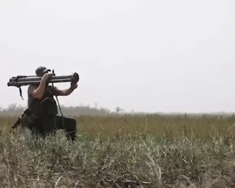 Soldier holding an RPG-30 shoulder-fired rocket launcher in a field