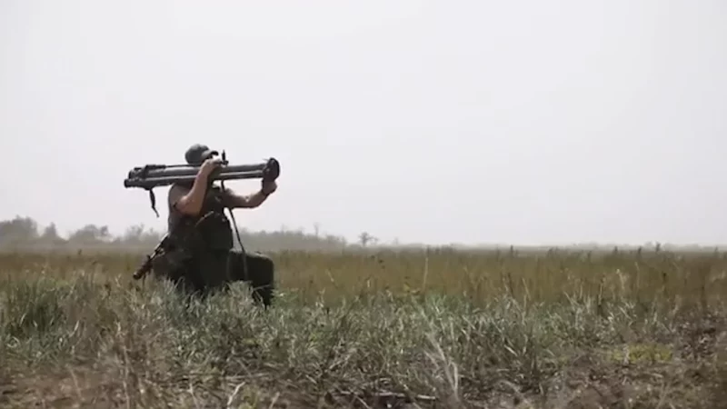 Soldier holding an RPG-30 shoulder-fired rocket launcher in a field