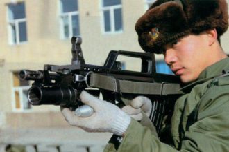 A Chinese soldier hodling an assault rifle with mounted QLG-10 underbarrel grenade launcher